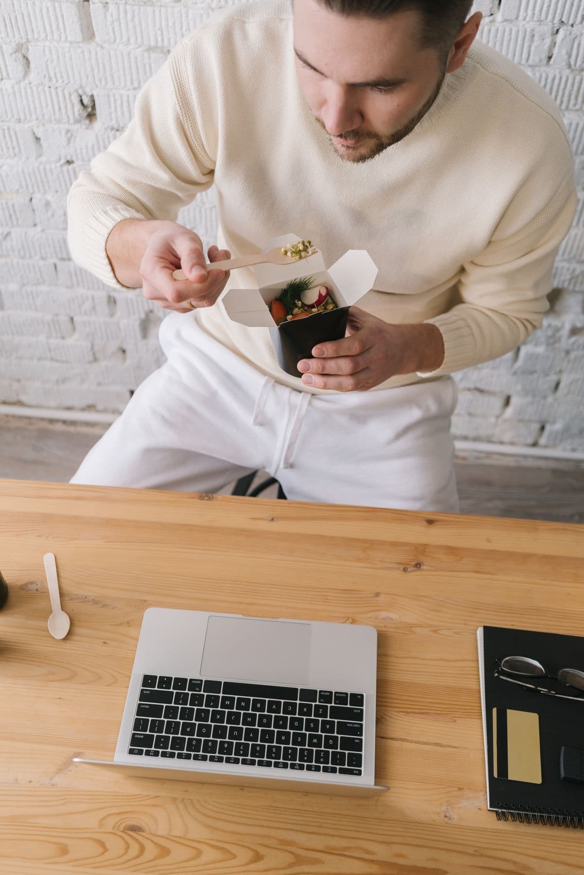 Someone on a work break eating a simple, real meal at their workspace — fitting health into a full schedule.