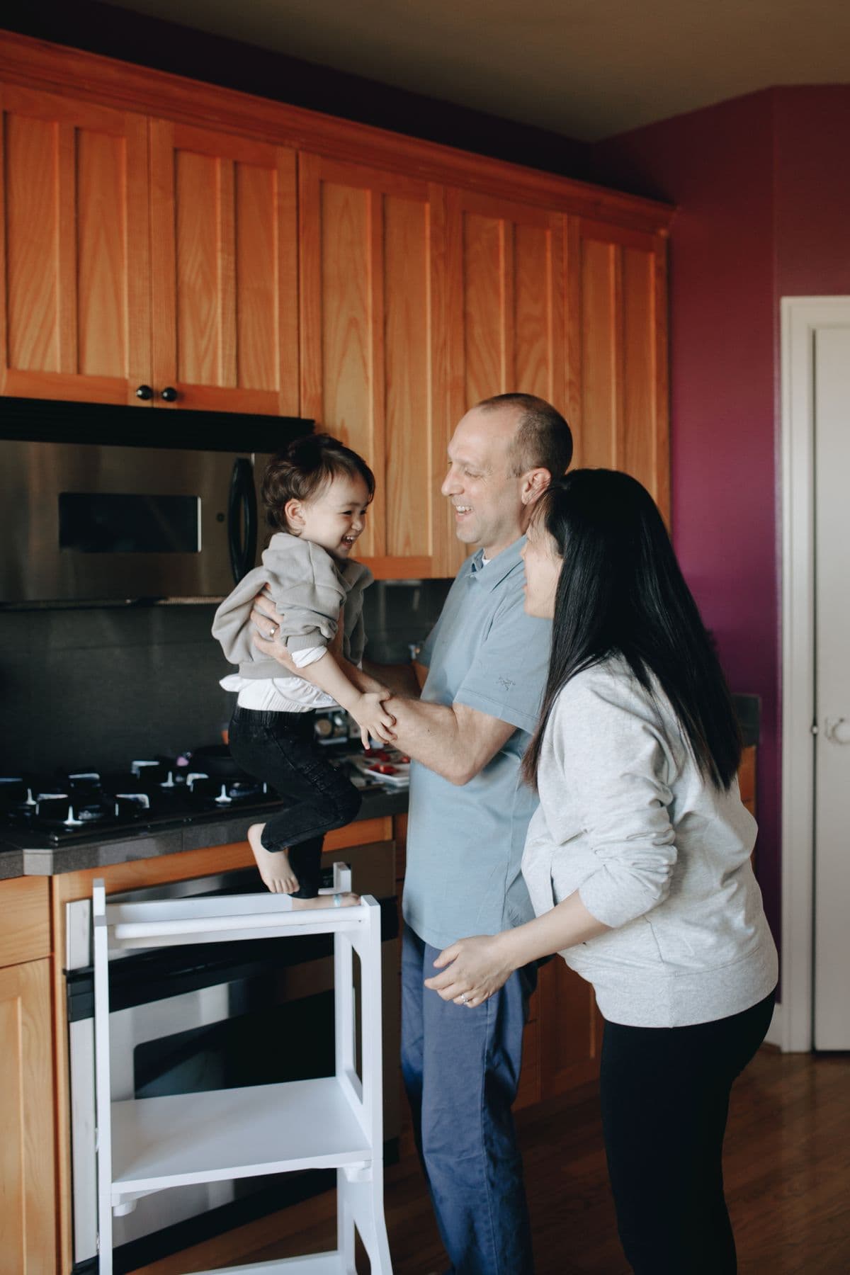 A household cooking together in a lived-in kitchen — warm evening light, ingredients mid-prep, no posed smiles.